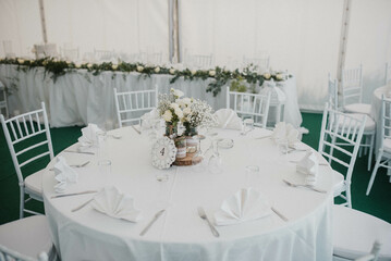 Table setting at a luxury event and beautiful flowers on the table. Beautiful wedding arch of flowers.