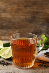 Glass cup of tasty bergamot tea on wooden table
