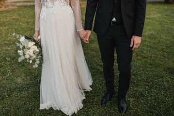 Newlywed romantic wedding couple walking. The bride and groom walk holding hands.