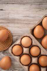 Fresh brown chicken eggs in a kraft paper egg carton.