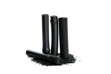 Activated carbon powder and black bamboo sticks on white background