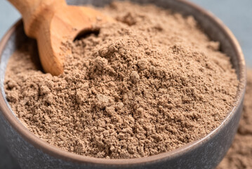 Close-up of flaxseed flour in a bowl. Side view, selective focus.