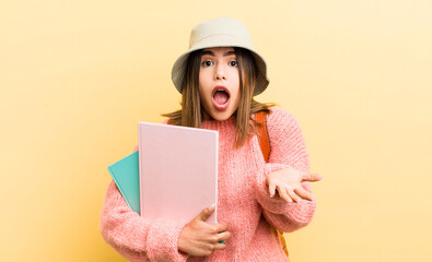 pretty hispanic girl amazed, shocked and astonished with an unbelievable surprise. student concept