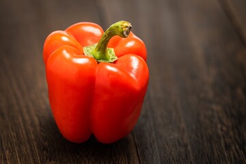 A red bell pepper or paprika on wooden floor, Vegetable or food background, Nobody	
