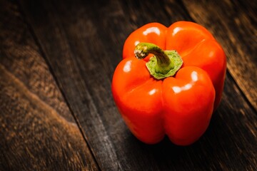 A red bell pepper or paprika on wooden floor, Vegetable or food background, Nobody	