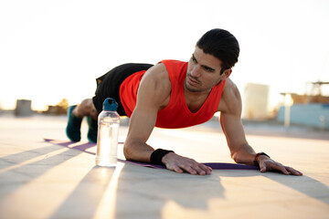 Young muscle man training outside. Fit handsome man doing exercise.