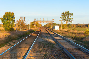 Deserted railroad tracks in the countryside under autumnal clear sky at sunset