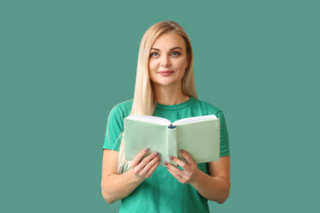 Beautiful woman reading book on green background