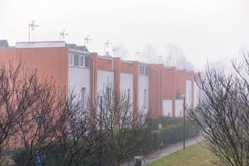Modern three-storey terraced houses on a foggy winter morning