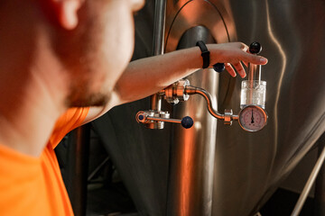 Man working at brewery details of beer kegs close up