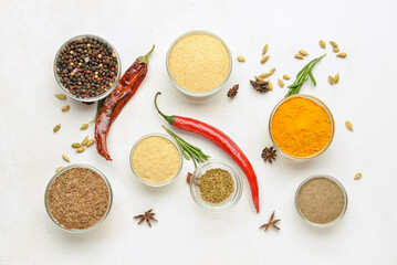 Composition with glass bowls of aromatic spices on light background