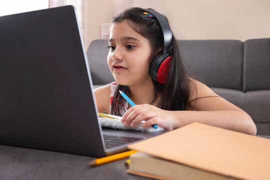 Girl studying online using laptop at home