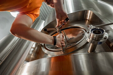 Man working at brewery details of beer kegs close up