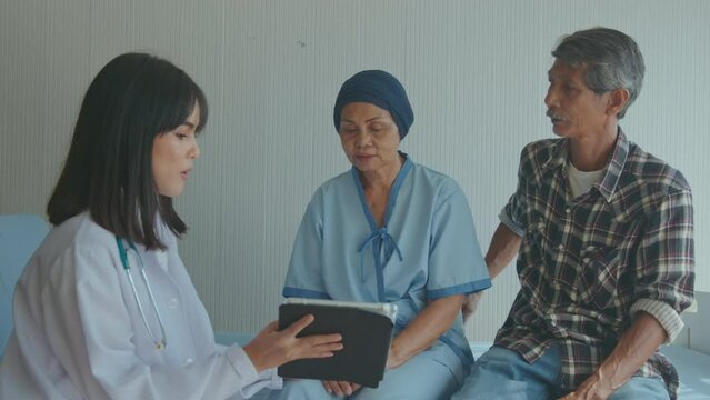 Cancer patient woman wearing head scarf after chemotherapy consulting and visiting doctor in hospital...