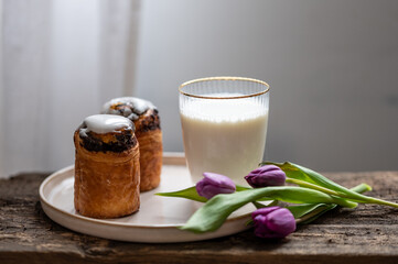 Chocolate swirl with milk and tulips on wooden table