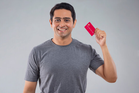 Portrait Of Happy Young Man Showing Credit Card