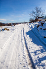 Fototapeta premium Winter Nature Landscape. Snow Covered Rural Road. Countryside Winters Scenery. Blue Sky. Hills And Fields.