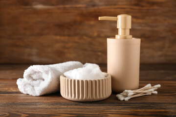 Set of bath supplies with cotton wool on wooden background