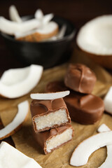 Delicious milk chocolate candy bars with coconut filling on table, closeup. Space for text