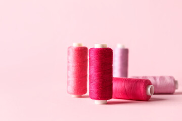 Different sewing threads on pink background