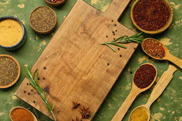 Composition with wooden board and aromatic spices on color background, closeup