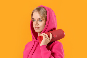 Young woman with wireless portable speaker on color background
