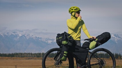 The woman travel on mixed terrain cycle touring with bikepacking. The traveler journey with bicycle...