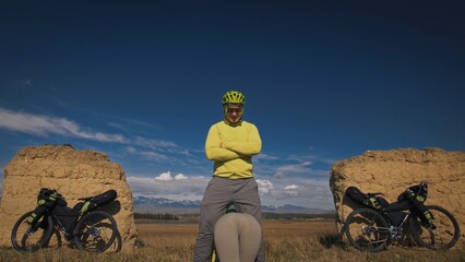 The man and woman travel on mixed terrain cycle bike touring with bikepacking. The two people...