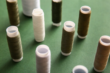 Thread spools on green background, closeup