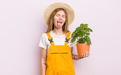 redhead pretty girl with cheerful and rebellious attitude, joking and sticking tongue out. plant...