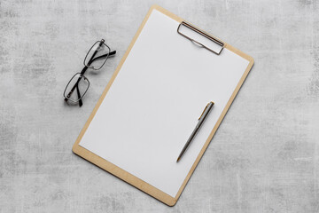 White office desk table with empty paper on clipboard