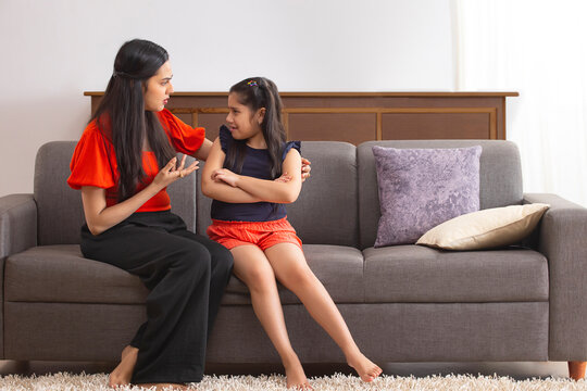 Mother scolding her daughter by showing her slap