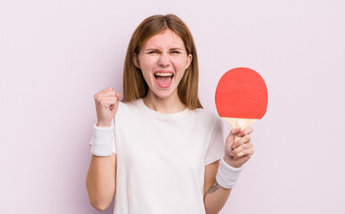 redhead pretty girl feeling shocked,laughing and celebrating success. ping pong concept