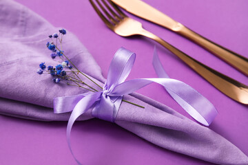 Simple table setting with flowers on purple background, closeup