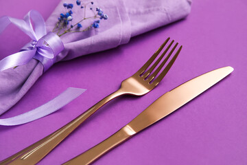 Simple table setting with flowers on purple background, closeup