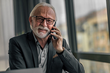 Handsome senior man businessman entrepreneur making a phone call looking at camera