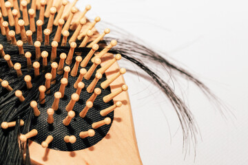 Wooden comb with fallen hair on it and scissors.