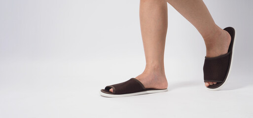 Asian female foot and wear slipper isolated on white background. - obrazy, fototapety, plakaty