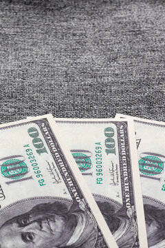 Vertical photo with American paper dollars. Hundreds of US dollars on a fabric background.