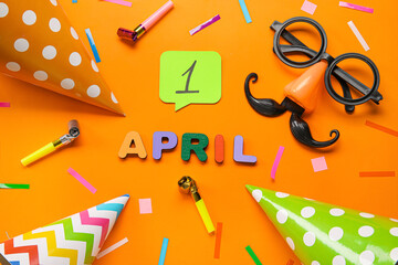 Composition for April Fools Day and party decor on orange background