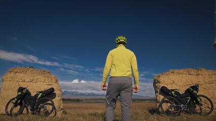 The man travel on mixed terrain cycle touring with bikepacking. The traveler journey with bicycle...