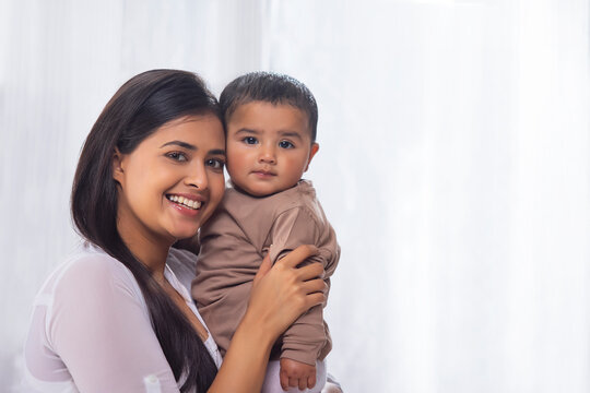 Portrait of happy mother with little baby at home