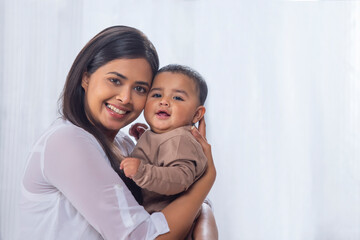 Portrait of happy mother with little baby at home