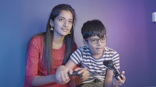Siblings fighting each other while playing video game at home - concept of brother and sister quarrel, bonding and entertainment