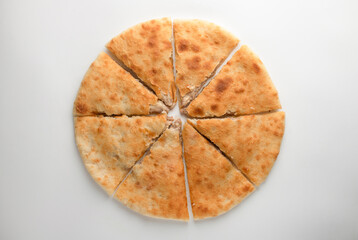 Ossetian pie with cheese and herbs on a white background