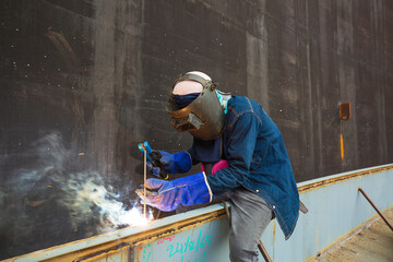 Welding male worker metal is part foam dam of machinery plate roof tank beam construction smoke