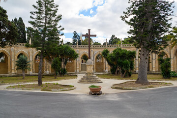 A cross between two trees in front of the Arcade for Tablets, a portico at the Santa Maria...