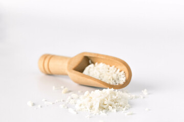 Coconut powder spice in wooden spoon, isolated on white background.