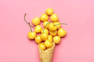 Fresh yellow cherries in waffle cones Ice cream cone filled with fresh sweet cherry on green background. Top view. Copy space. Summer creative concept Flat lay Healthy food