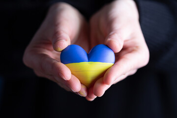 Heart flag of Ukraine in human hands. No war, peace for Ukraine concept.